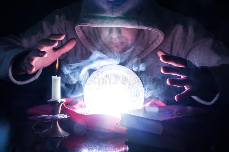 wizard-hood-lights-smoke-magic-crystal-ball-white-desk-candle-candlestick-old-books-predicting...jpg